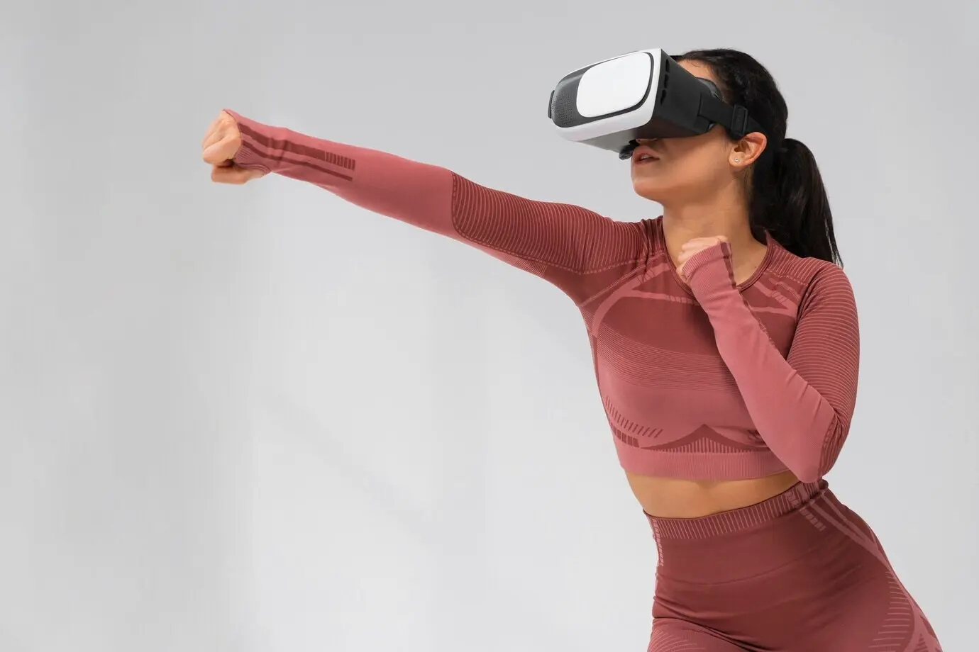 Plano medio de una mujer entrenando con gafas de realidad virtual puestas.