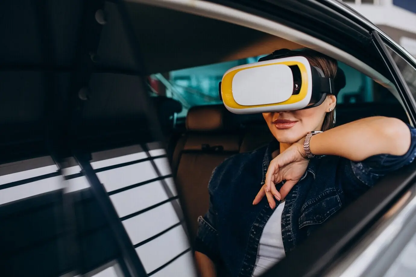 Mujer sentada dentro de un automóvil usando gafas de realidad virtual.