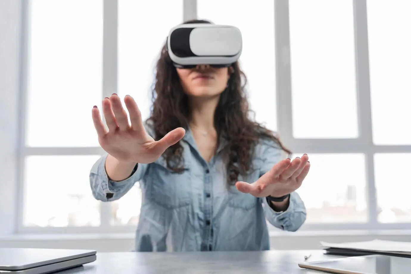 Mujer usando realidad virtual en una oficina de negocios, vista desde un ángulo bajo.